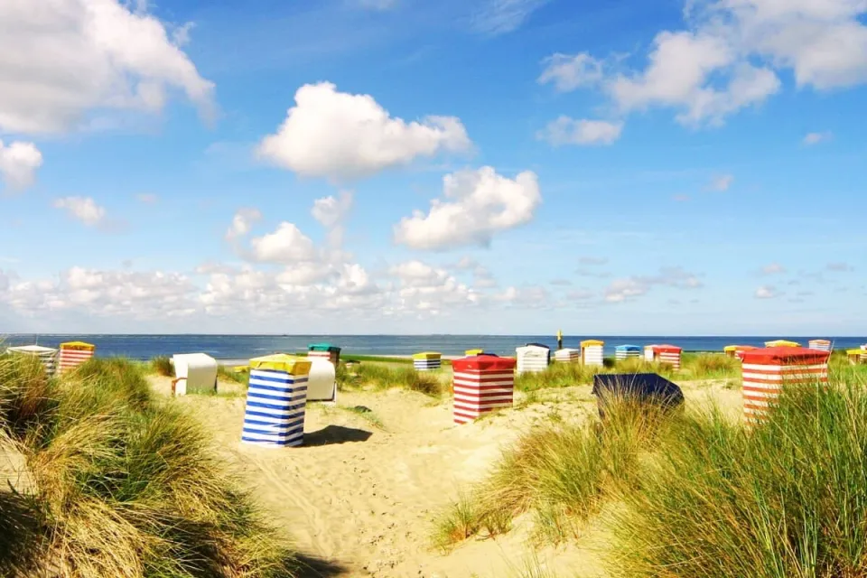 strand op Norderney met Strandkorbe en de zee op de achtergrond