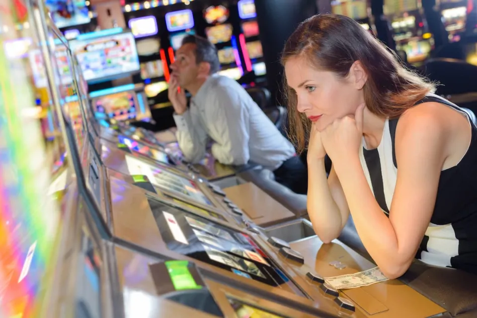 verveelde vrouw in casino bij gokkast