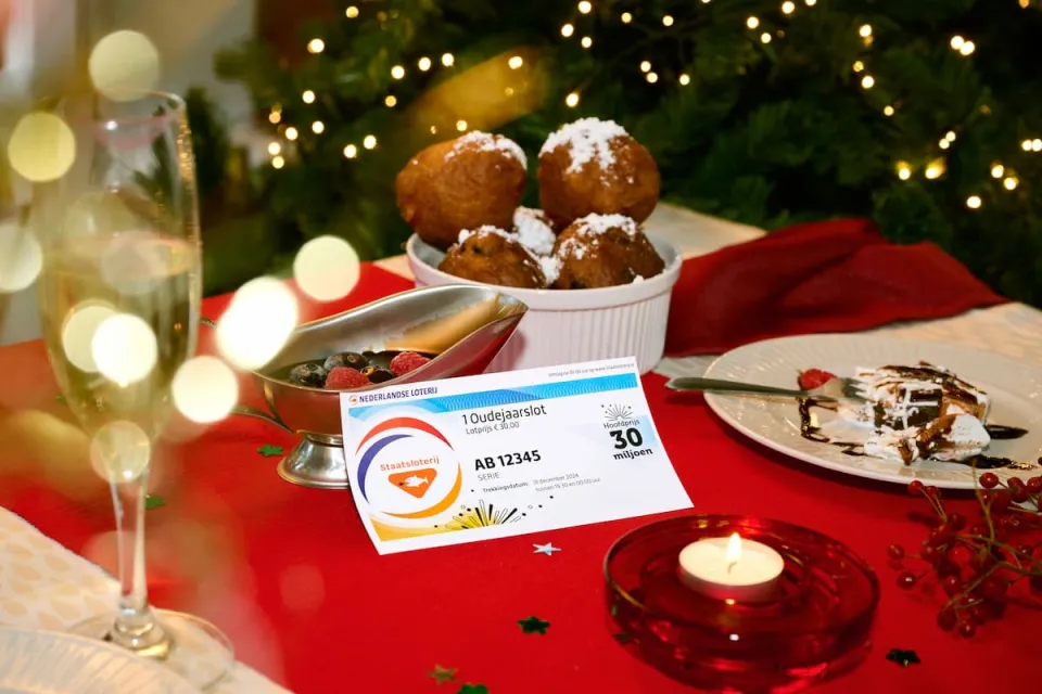 Ouderjaarslot met oliebollen op een feestelijk gedekte tafel