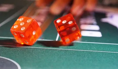 hand werpt twee dobbelstenen op craps tafel